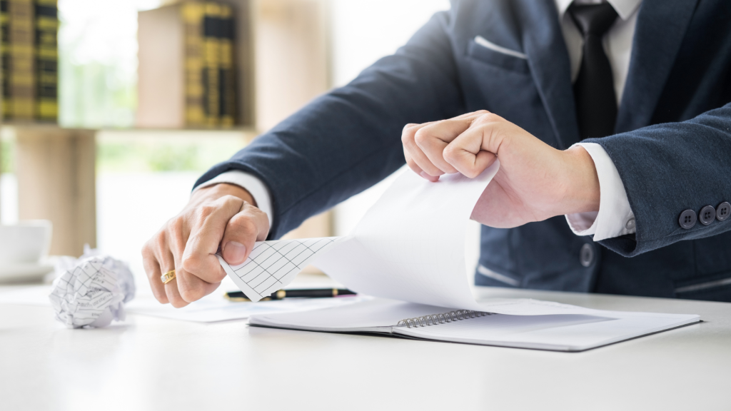 en man river ett papper.