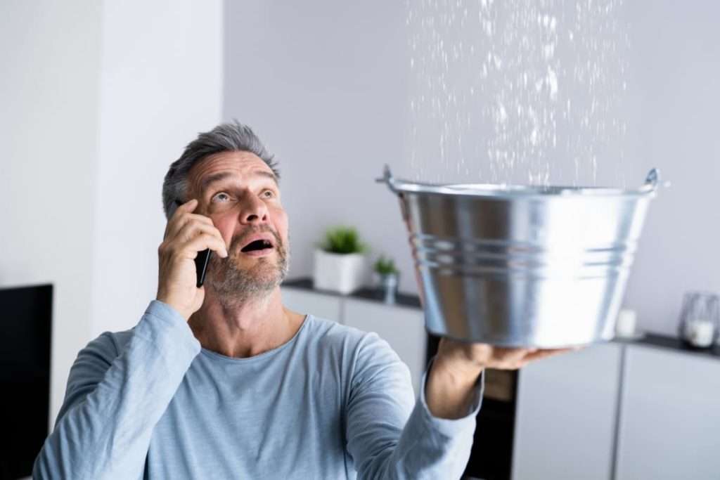 Fångar upp vatten från taket med en hink
